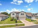 Two-story home boasts manicured lawn, two-car garage, and charming curb appeal on a sunny day at 9095 Rally Spring Loop, Wesley Chapel, FL 33545