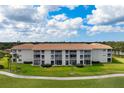 Beautiful condo building featuring a red tile roof, screened balconies, and well-maintained landscaping at 9630 Club South Cir # 6201, Sarasota, FL 34238