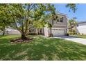 Charming two-story home with a manicured lawn and two-car garage at 10615 Boyette Creek Blvd, Riverview, FL 33569