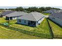 Backyard featuring a well-maintained lawn, a black fence, and an inviting outdoor seating area at 11869 Richmond Trl, Parrish, FL 34219