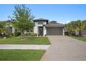 Beautiful single-Gathering home featuring manicured lawn, paved driveway, and elegant exterior lighting at 14514 20Th E St, Parrish, FL 34219
