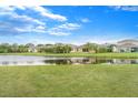 Backyard view of a scenic pond and homes, with birds wading in the shallow waters at 14914 Flowing Gold Dr, Bradenton, FL 34212