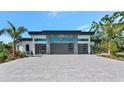 Modern home featuring a three-car garage, sleek architectural design, and attractive landscaping at 1555 Eastbrook Dr, Sarasota, FL 34231