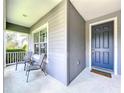Inviting front porch with seating area and a stylish blue front door at 16848 Rosedown Gln, Parrish, FL 34219