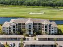 Aerial view of condo complex, water feature, golf course, and covered parking under blue sky at 17902 Gawthrop Dr # 107, Bradenton, FL 34211