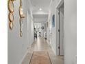 Hallway features neutral tile flooring, white walls, decorative mirrors, and arched doorways at 17902 Gawthrop Dr # 107, Bradenton, FL 34211