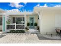 Charming home exterior with a covered porch featuring decorative lattice and a bright teal front door at 1907 4Th W St, Palmetto, FL 34221