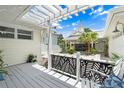Inviting outdoor patio area with a pergola, white railings with leaf design, and garden views at 1907 4Th W St, Palmetto, FL 34221