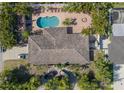 Aerial view of a property featuring a pool, patio, lush landscaping, and driveway at 2609 Webber St, Sarasota, FL 34239