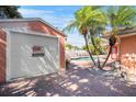 Garage with brick paver driveway, surrounded by tropical landscaping, offering both convenience and curb appeal at 2609 Webber St, Sarasota, FL 34239