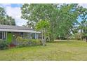 View of home with large yard, mature trees, and lush landscaping creates a peaceful setting at 2906 Arlington St, Sarasota, FL 34239