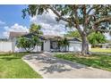 Charming single-story home featuring a well-manicured lawn, mature tree, and a two-car garage at 322 Linden Dr, Ellenton, FL 34222