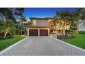 Elegant two-story home boasts mature trees, lush landscaping, and a paver driveway at 3272 Bayou Rd, Longboat Key, FL 34228