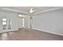Bright living room with wood flooring, tray ceilings, and double glass doors at 3812 Wenona Dr, North Port, FL 34288