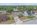 An aerial view shows a single Gathering home with landscaping, a long driveway with white car, and a light brown roof at 4053 Lancaster Dr, Sarasota, FL 34241