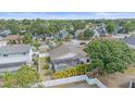 An aerial view shows a home with a screened pool surrounded by palm trees and a white fence and green trees at 4053 Lancaster Dr, Sarasota, FL 34241