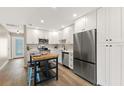 Bright kitchen featuring white cabinets, stainless steel appliances, and a butcher block island with seating at 420 63Rd St # B East, Holmes Beach, FL 34217