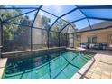 Relaxing screened pool with brick pavers and views of the surrounding trees and blue skies at 437 Chantilly Trl, Bradenton, FL 34212