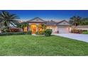 Stunning home exterior with a lush green lawn, mature palm trees, and a two-car garage at 4832 Carrington Cir, Sarasota, FL 34243
