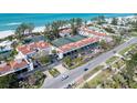 Aerial view showcasing a coastal community with tennis courts and beachfront access near Gulf of Mexico at 5055 Gulf Of Mexico Dr # 414, Longboat Key, FL 34228