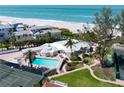 Aerial view of community pool, hot tub, and lush landscaping perfect for enjoying the Florida lifestyle at 5055 Gulf Of Mexico Dr # 414, Longboat Key, FL 34228
