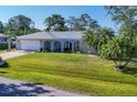 Landscaped front yard featuring a lush lawn, palm trees, and beautiful curb appeal at 5206 18Th E Ave, Bradenton, FL 34208
