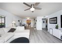 Bright living room featuring wood-look floors, ceiling fan and open layout to the kitchen at 6100 Gulfport S Blvd # 117, Gulfport, FL 33707