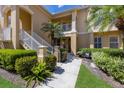 Attractive condo exterior with white railings, lush landscaping, and well-manicured grounds at 7155 Boca Grove Pl # 102, Lakewood Ranch, FL 34202
