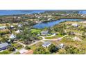 An aerial view shows the area and neighboring homes on the water with lush trees and vibrant landscapes at 80 Liles St, Terra Ceia, FL 34250