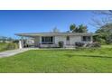 Lovely single-story home with a green lawn, covered parking, manicured shrubs, and a clean, welcoming facade at 80 Liles St, Terra Ceia, FL 34250