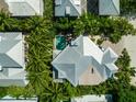 Aerial view showcasing the house, its pool, and the lush surrounding greenery at 103 Park Ave, Anna Maria, FL 34216