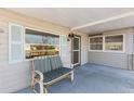 Close-up of the covered front porch, featuring a comfortable bench and access to the home's entrance at 10315 Cortez W Rd # 24-5, Bradenton, FL 34210