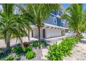 View of the side of the home, beautiful landscaping and white fence at 201 Bay N Dr, Bradenton Beach, FL 34217