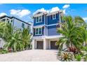 Beautiful two-story blue home featuring a gravel driveway, landscaping, and a two-car garage at 201 Bay N Dr, Bradenton Beach, FL 34217