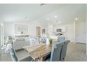 Open-concept space with a wooden dining table and upholstered chairs, flowing into the living room at 20276 Emerald Ave, Port Charlotte, FL 33952