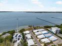 Aerial view of waterfront homes, featuring pristine water views, a long fishing pier, and lush landscaping at 2107 Palma Sola Blvd # 95, Bradenton, FL 34209