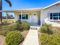 Inviting front porch with white columns, complemented by lush greenery and a well-maintained walkway at 214 49Th W St, Bradenton, FL 34209