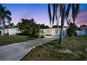 Charming single-story home with lush landscaping, a long driveway, and vibrant blue doors at 2307 Valencia Dr, Sarasota, FL 34239