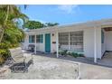 Charming home features a blue door and shutters, and a cozy front sitting area at 2307 Valencia Dr, Sarasota, FL 34239
