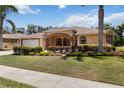 Attractive single-story home with verdant lawn, decorative shrubs, and a two-car garage at 3108 River Woods Dr, Parrish, FL 34219