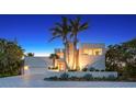 Stunning modern home featuring palm trees and a well-manicured front yard under a beautiful twilight sky at 360 N Washington Dr, Sarasota, FL 34236