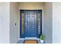 The front door is a beautiful blue, with decorative windows on either side, and an electronic lock at 4415 Sylvania Ave, North Port, FL 34286