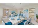 Bright dining room with blue and white decor, white table, and open layout to kitchen and living areas at 4908 Commonwealth Rd, Palmetto, FL 34221
