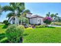 Well-manicured lawn and tropical landscaping surrounding a charming single-story home at 5437 Manchini St, Sarasota, FL 34238