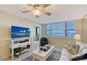 Bright living room featuring a ceiling fan and large window with shutter blinds at 5855 Midnight Pass Rd # 512, Sarasota, FL 34242