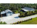 Expansive property featuring a house, garage, and gravel driveway surrounded by trees, offering privacy at 6365 Jim Davis Rd, Parrish, FL 34219