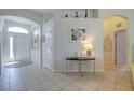 Inviting foyer with tile floors, arched doorways, neutral paint, and decorative shelving above a white wall at 6412 Golden Eye Gln, Lakewood Ranch, FL 34202