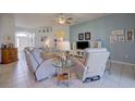 Open-concept living room with tile flooring, neutral furniture, ceiling fan, and an arched doorway leading to the foyer at 6412 Golden Eye Gln, Lakewood Ranch, FL 34202