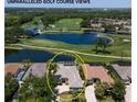 Stunning aerial view of home with a screened pool overlooking a picturesque golf course and serene lake at 8715 52Nd E Ave, Bradenton, FL 34211