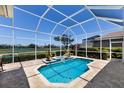 Screened pool with brick patio offers relaxing outdoor living with views of lush landscaping and a golf course at 8715 52Nd E Ave, Bradenton, FL 34211